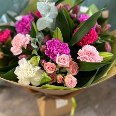 Pink Whispers - A romantic medley of pinks and pastels with carnations, spray roses, lisianthus and eucalyptus for texture. A classic choice with a modern touch.