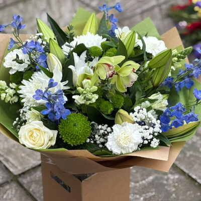 Tranquil Sky - Soothing whites, soft greens and delicate blues combine in this calming bouquet with roses, orchids, delphiniums and lisianthus. A serene statement.