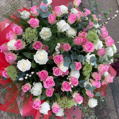 50 Shades of Pink - A grand hand-tied bouquet overflowing with pink and white roses, soft greenery, and fluffy accents. Romantic, extravagant, and unforgettable.