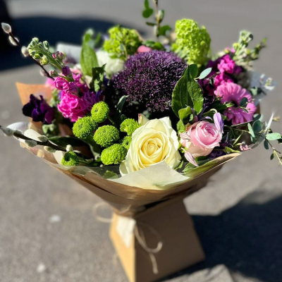 Berry Breeze - A cool-toned hand-tied with purples, pinks, and greens including alliums, carnations, stock, and lilac roses. Rich with texture and colour, perfect for cooler seasons.