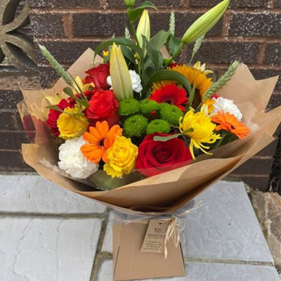 Sunset Sky - A stunning handtied with seasonal flowers a mix of red, orange and yellow, with complimentary foliage. Hand delivered Wellington and surrounding areas by Bloomin Lovely.